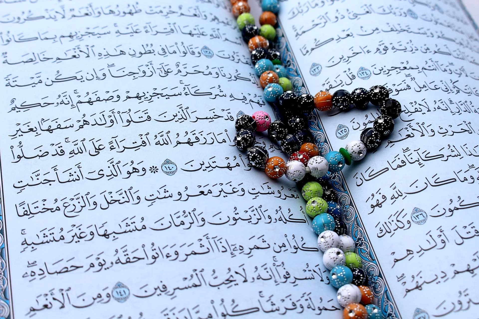 Student practicing Tajweed rules while reading the Quran with a teacher